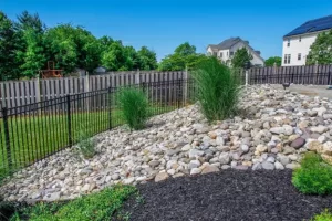 Budget-friendly landscaping and lawn design by Hawkins Landscaping Inc, featuring decorative rocks, ornamental grasses, and a clean backyard layout.