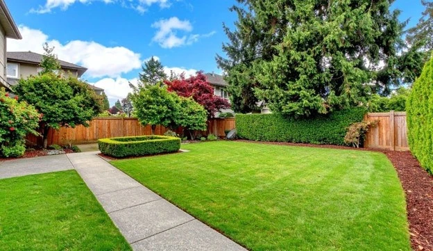 Well-kept green lawn and garden showing expert lawn care Frederick by Hawkins Landscaping.