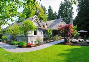 Beautiful front yard with landscaping and hardscaping features designed by Hawkins Landscaping, including a stone walkway, trimmed shrubs, and vibrant garden plants.
