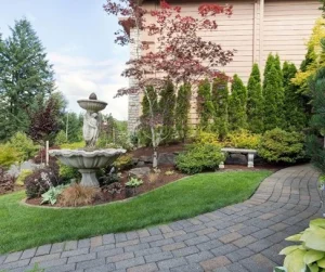 Hardscapes landscaping by Hawkins Landscaping, featuring a beautifully paved path, a stunning water fountain, and lush greenery, creating a serene and low-maintenance outdoor space.