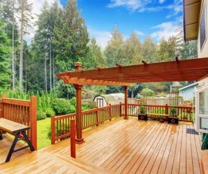 Pergolas for decks by Hawkins Landscaping featuring a spacious wooden deck with a stylish pergola structure, creating shade and enhancing the outdoor living space.