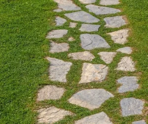 Walkways for backyard by Hawkins Landscaping featuring natural stone paths set in green grass.