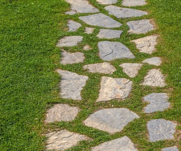 Walkways for backyard by Hawkins Landscaping featuring natural stone paths set in green grass.