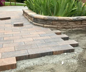 Walkways for backyard using stone pavers beside a raised garden wall by Hawkins Landscaping.