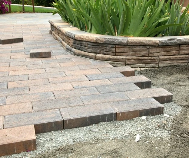 Walkways for backyard using stone pavers beside a raised garden wall by Hawkins Landscaping.